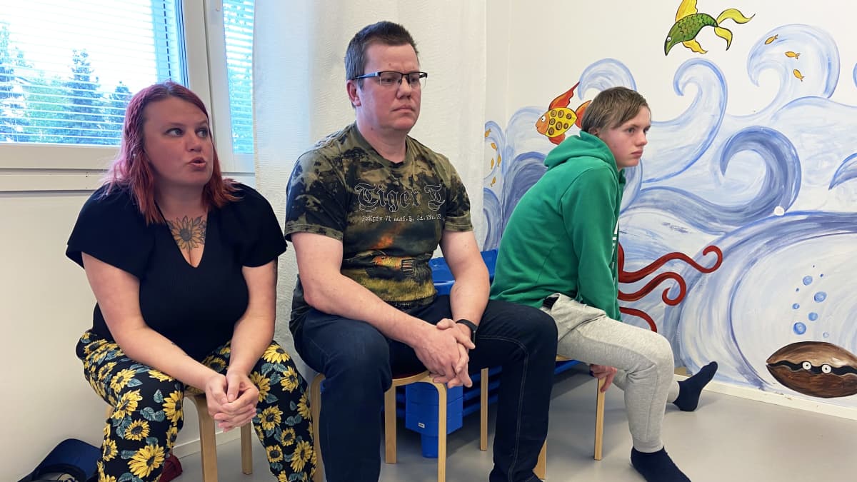 Lapualaiset Marjo, Jani ja Mikael Nurmenniemi istuvat kuuntelemassa Lapuan yläkoulun sisäilmaongelmia koskevaa keskustelua.