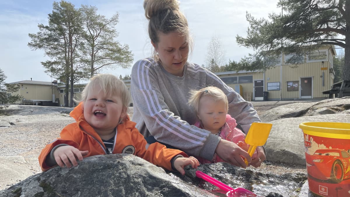 Annika Kuronen lastensa kanssa hiekkaleikeissä.