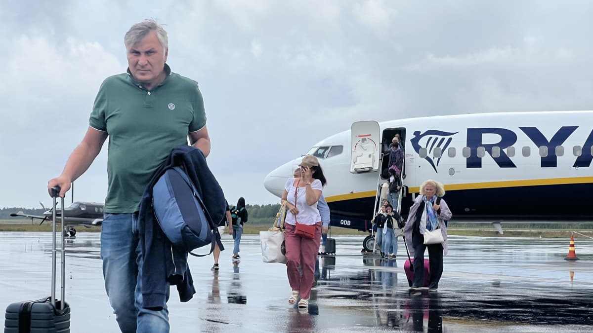 Ryanairin lentokone Lappeenrannan lentokentällä. Matkustajia tulee ulos kentyälle.