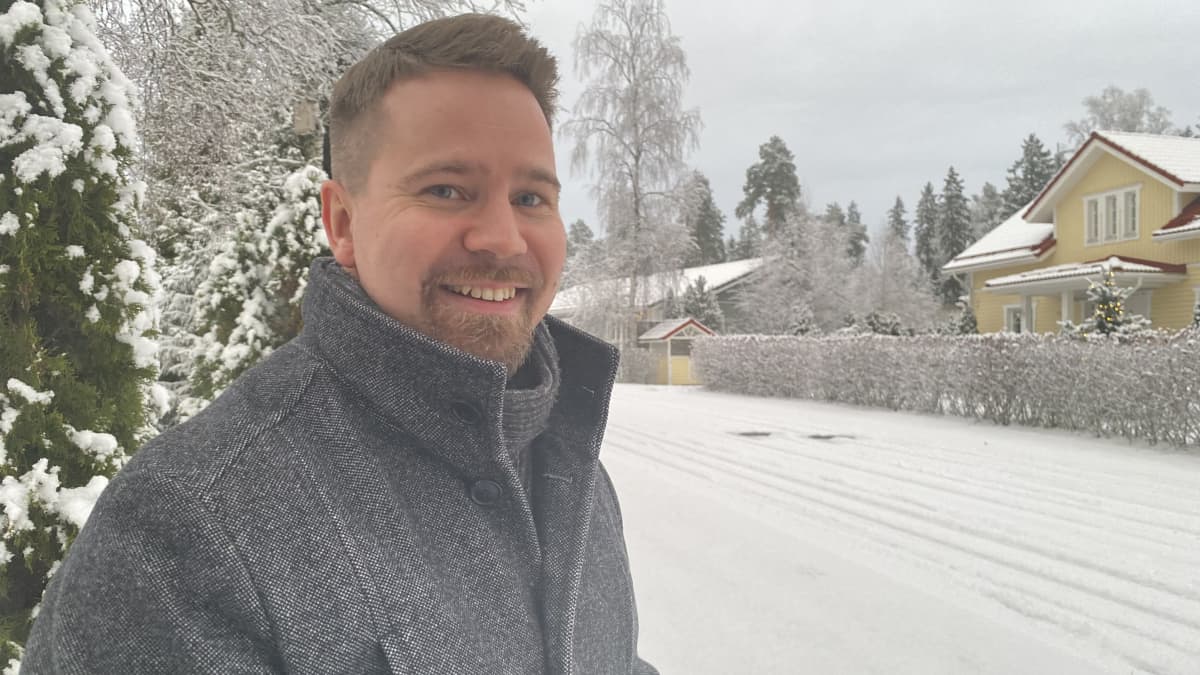 Mies katsoo kameraan ja hymyilee.