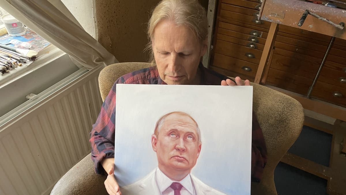 Taidemaalari katsoo maalaanmaansa kuvaa Venäjän presidentistä. 