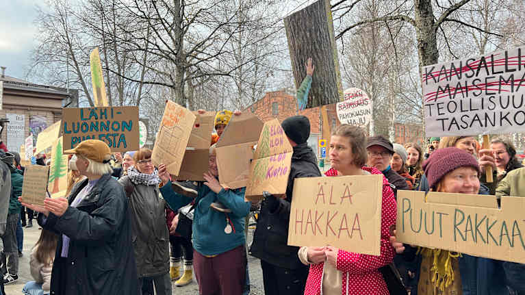 Mielenosoittajia Kuopion valtuustotalon edessä.