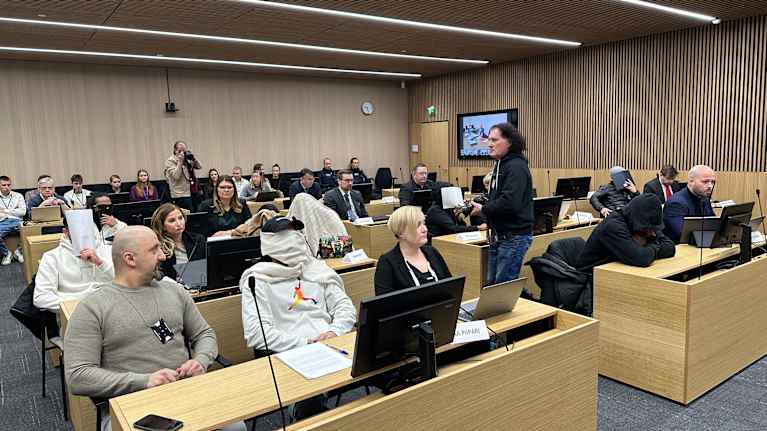 People sat in the courtroom, some covering their faces.