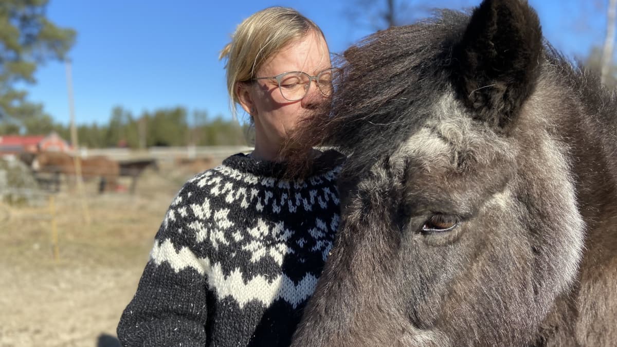 Nainen Riikka Lamminen nojaa islannin hevosen harjaan