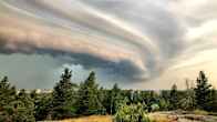 A torrential cloud caused by a hailstorm in a wide landscape.