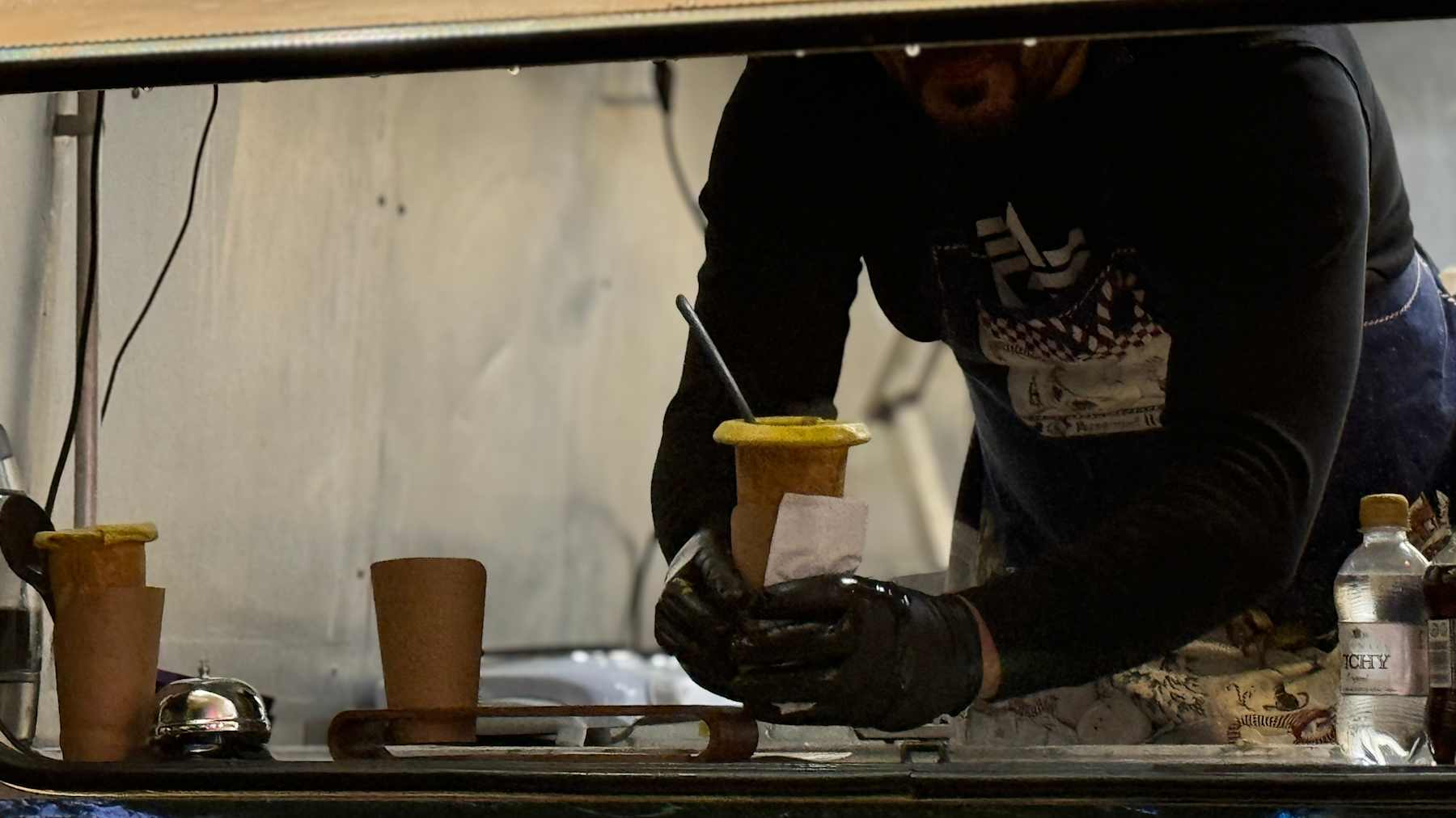 a man in a minivan holding freshly made soup in an edible bread cup.