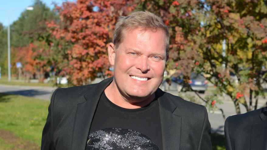 Mies hymyilee leveästi.