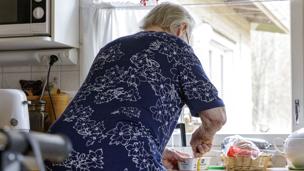 Leena Pulkkinen tekee leipiä omassa keittiössään selkä kameraan päin.