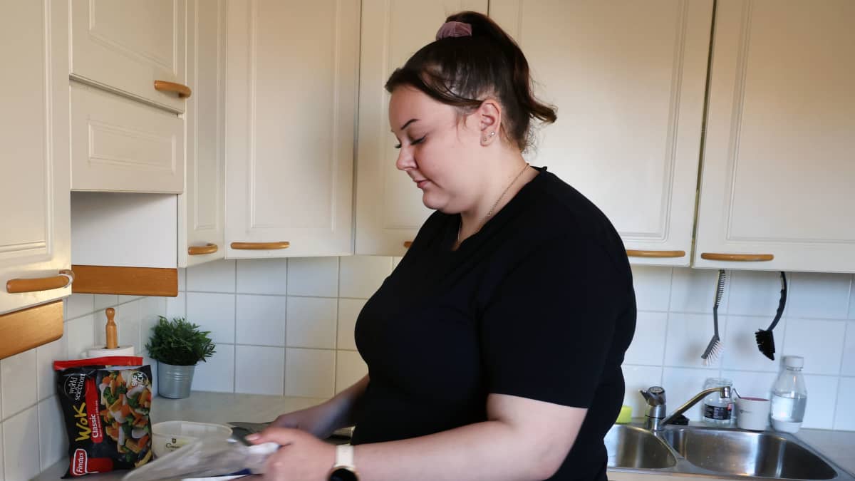 Tanya Huovilainen laittamassa kanaa paketista pannulle.