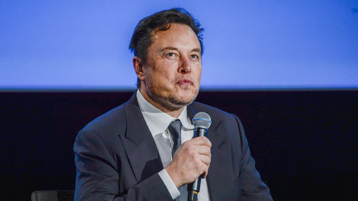 Elon Musk istuu tuolilla ja pitelee mikrofonia kädessään Norjassa 29. elokuuta 2022.