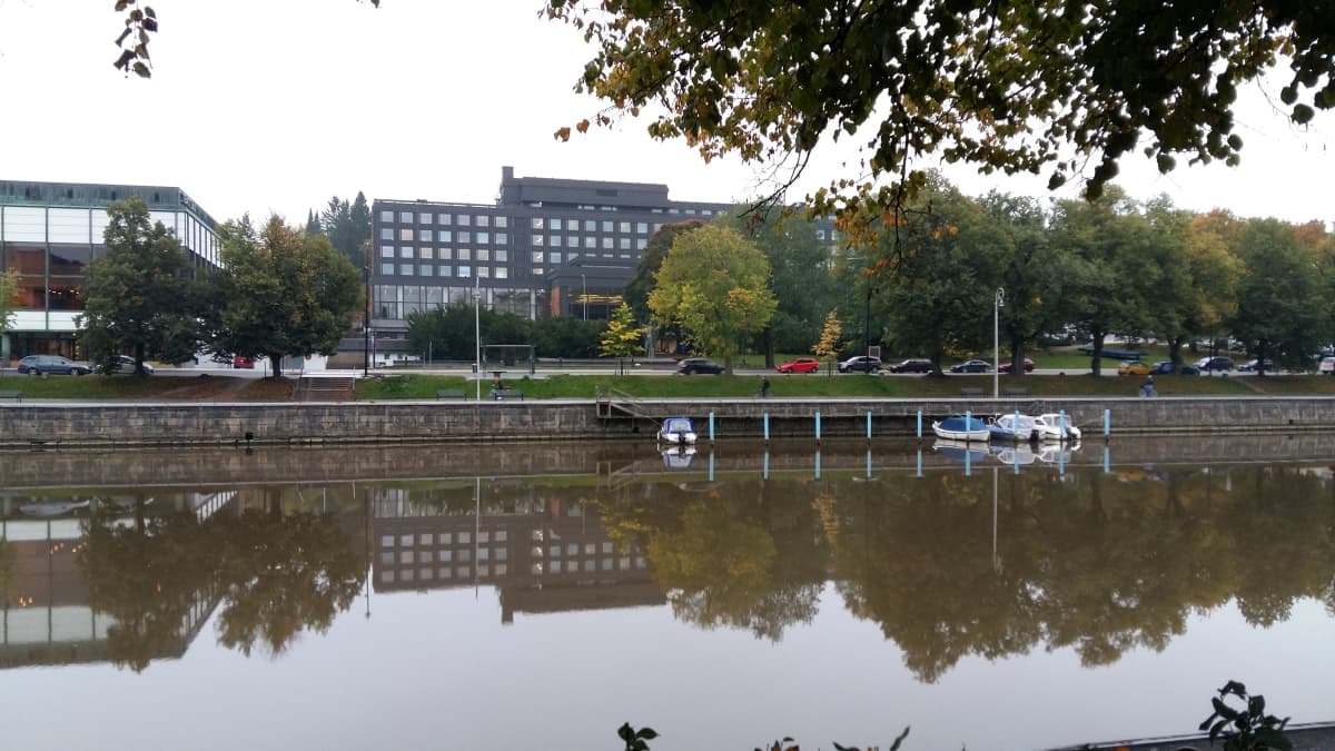 Statens ämbetshus i Åbo speglas i Aura å en höstdag.