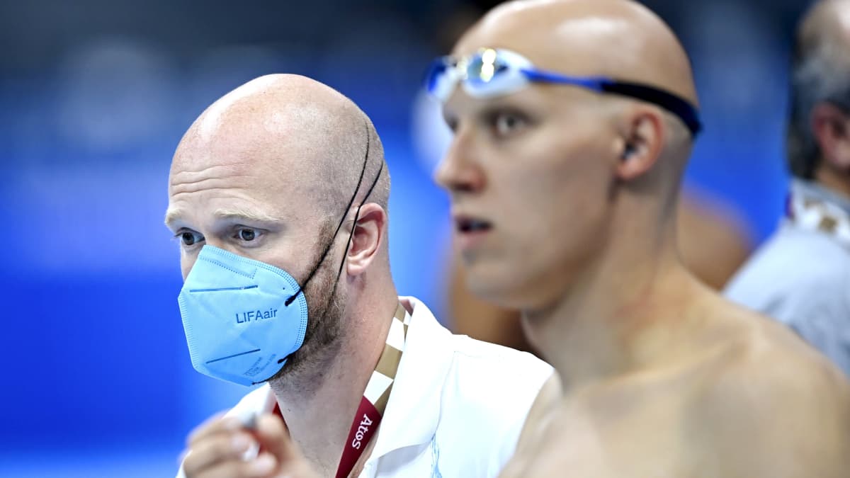 Kuvassa etualalla uimari Matti Mattsson uimalasit päässä, takana Mattssonin valmentaja Eetu Karvonen hengityssuoja kasvoilla.