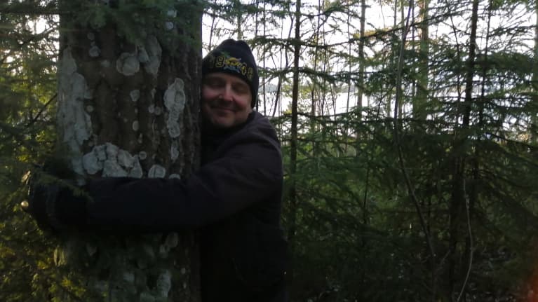 Kimmo Saarinen halaa puuta
