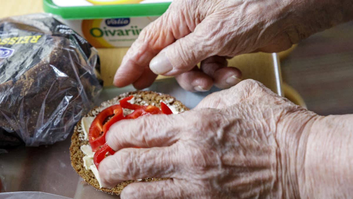Vanhan naisen kädet tekemässä leipiä.