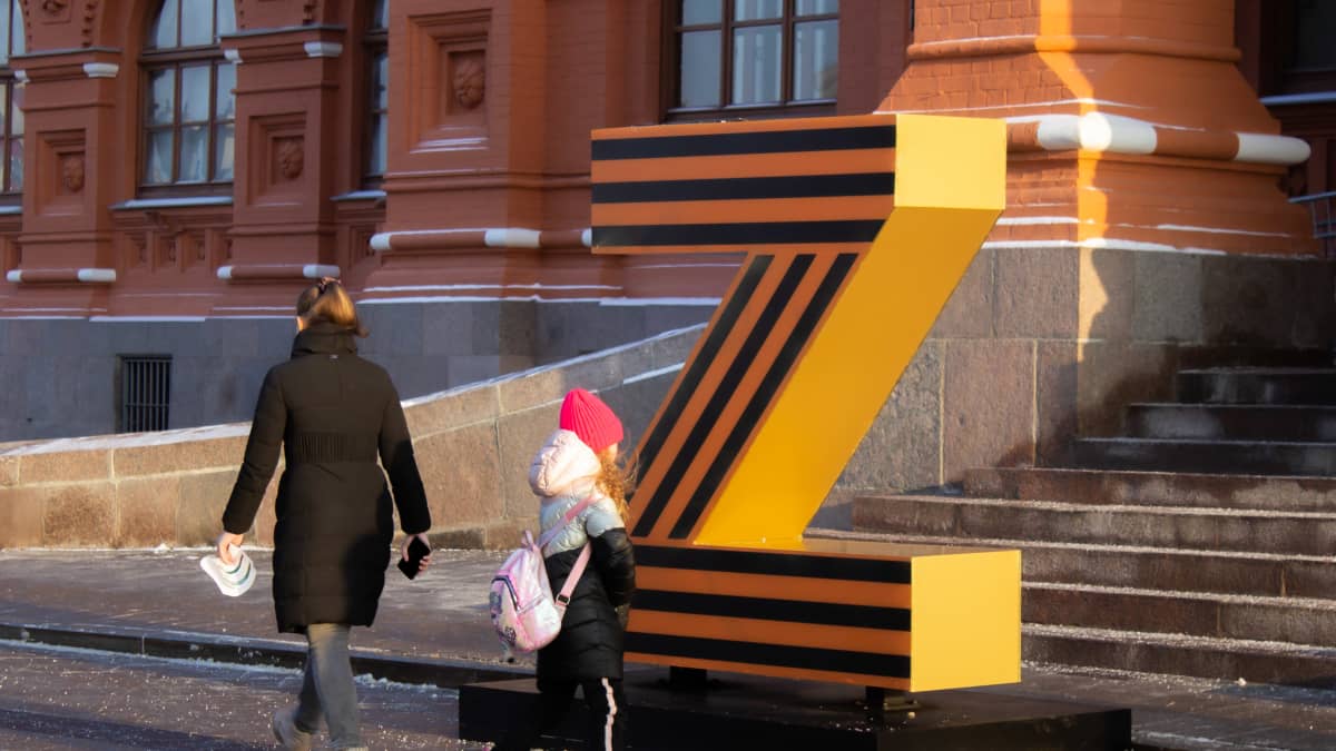 Tyttö katselee suurta Z-merkkiä Moskovan punaisella torilla.