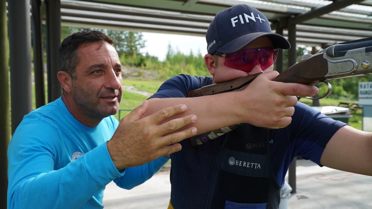 Skeet-ammunta maajoukkueen valmentaja Pietro Genga opastaa ampuja Eetu Kallioista ampumaradalla.