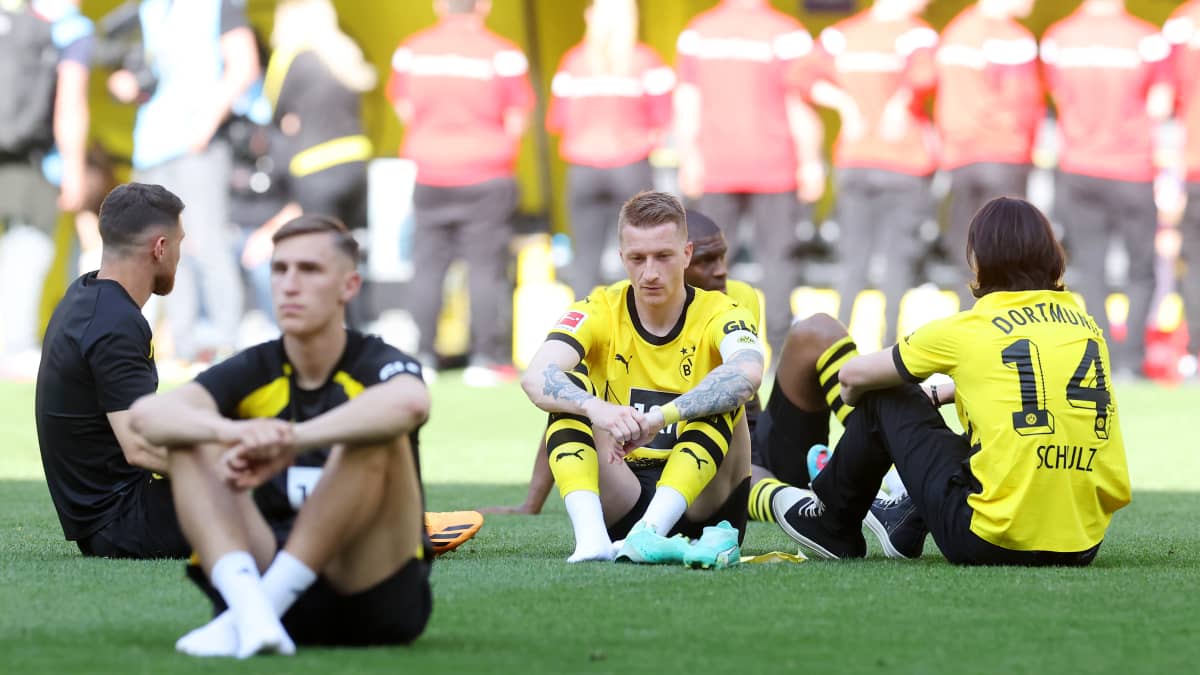 Dortmundin pelaajat istuivat pettyneinä kentällä. Keskellä joukkueen kapteeni Marco Reus.