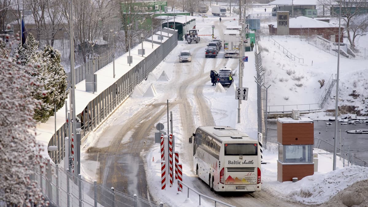 Bussi ajamassa rajasillalle Narvan kaupungissa Virossa, taustalla Venäjän rajaasema ja henkilöautoja jonottamassa.