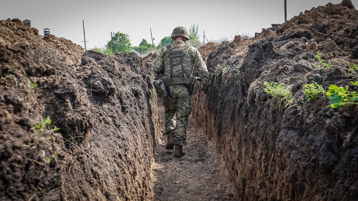 Ukrainalainen sotilas kävelee juoksuhaudassa.