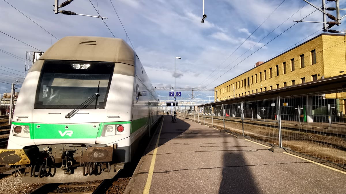 InterCity-juna asemalaiturilla, vieressä työmaaiadan takana poistettuja raiteita Turun päärautatieaseman edustalla.