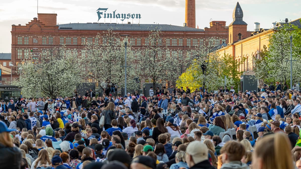 Aurinkoinen Keskustori täynnä ihmisiä seuraamassa peliä screeniltä.