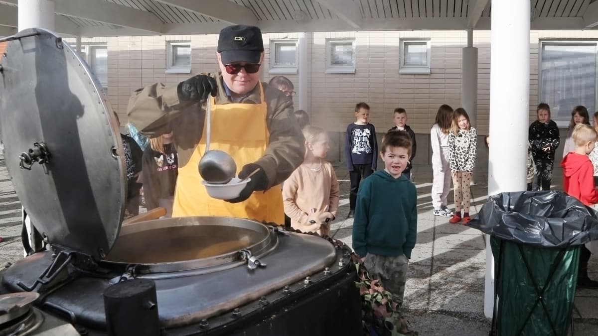 Yrittäjä Matti Henttunen jakaa koululaisille soppatykillä tehtyä keittoa Napapiirin ala-asteella Rovaniemellä.