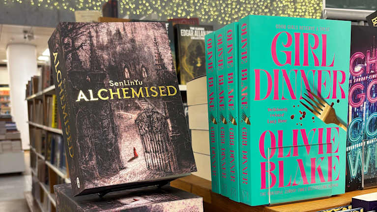 Romanerna Alchemised av SenLinYu och Girl Dinner av Olivie Blake står på paradplats i en bokhandel.