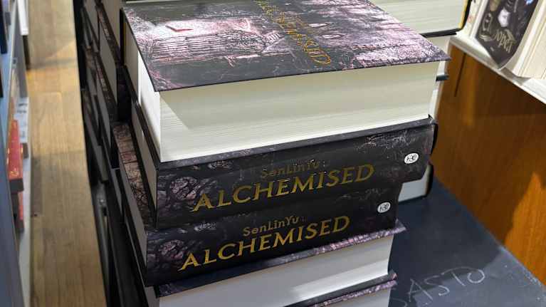 En kärra i en bokhandel, lastad med några tiotal exemplar av fantasyromanen Alchemised.
