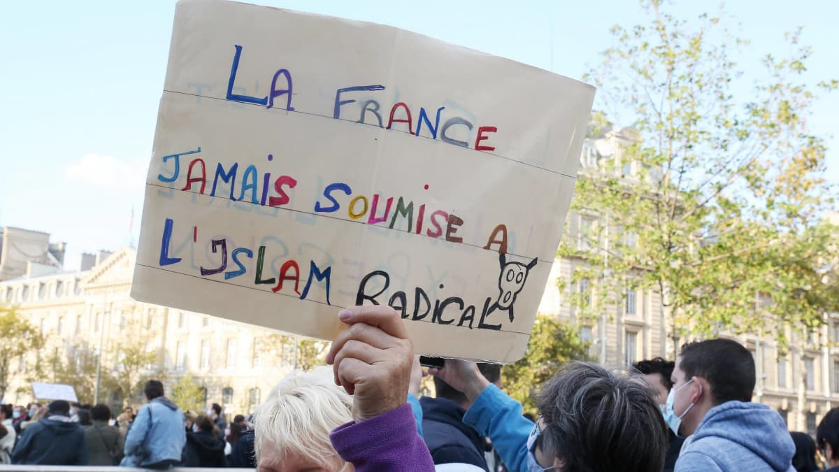 Nainen pitelee kylttiä, jossa lukee, ettei Ranska koskaan alistu islamismille.
