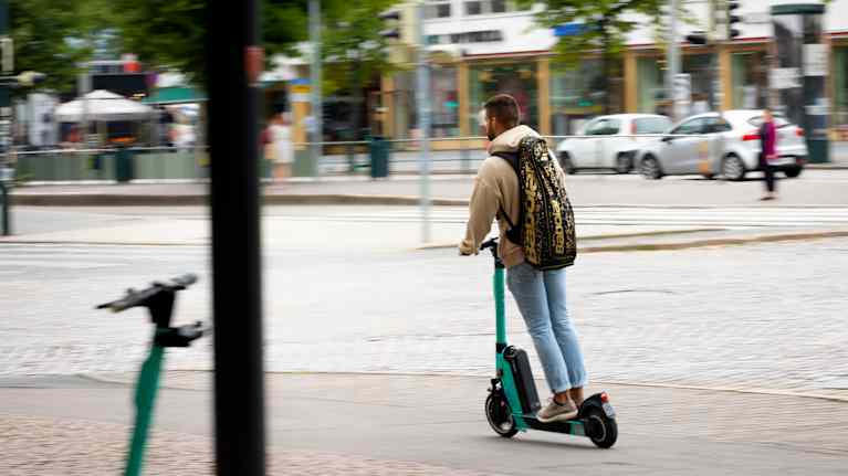 A man rides an electric scooter. 