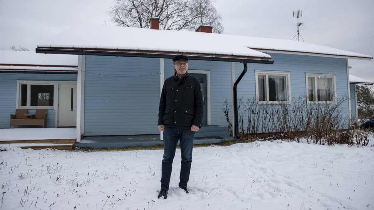Ari Vainio seisoo omakotitalon pihassa talvella