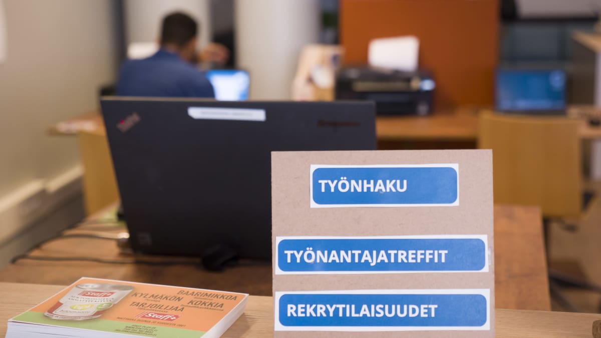 Photos shows a meeting between a jobseeker and a prospective employer at an office in Helsinki.