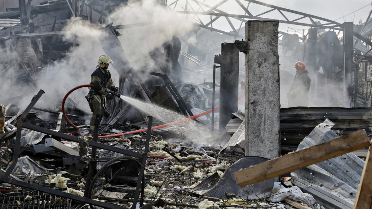 Palomiehet sammuttavat ohjuksen tuhoja Kiovassa 21. syyskuuta 2023.