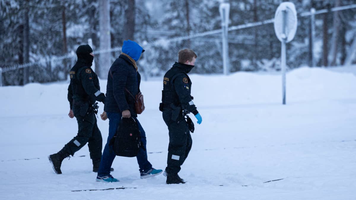 Rajavartijat saattavat siirtolaista Raja-Joosepin raja-asemalla. Kuva: Vesa Toppari / Yle