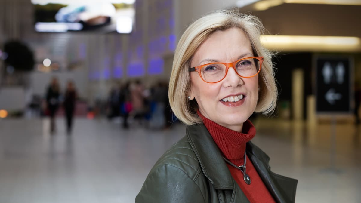 Saara Hassinen, terveysteknologian ry.:n toimitusjohtaja seisoo Helsingin messukeskuksen aulassa ja hymyilee..