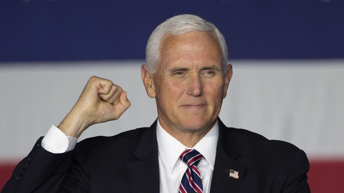 Mike Pence står bakom ett podium och håller höger näve lyft.