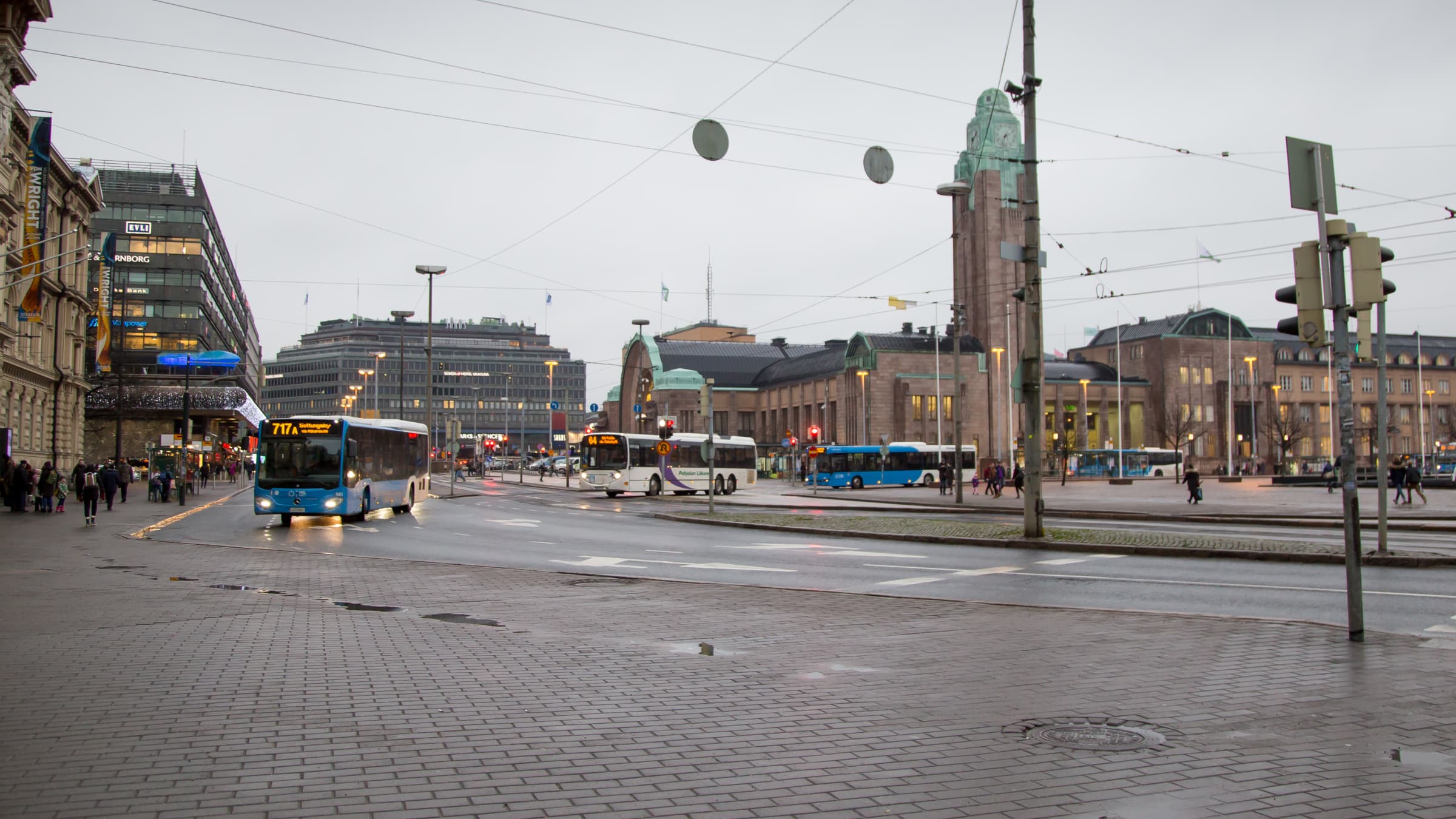 Kolme linja-autoa ajaa kadulle jonossa Helsingin Rautatientorilta.