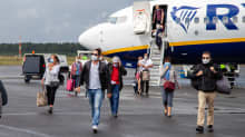 Italiasta tulleita ihmisiä kasvomaskeissa kävelee lentokoneesta Lappeenrannan lentoasemalla 1.7.2020.