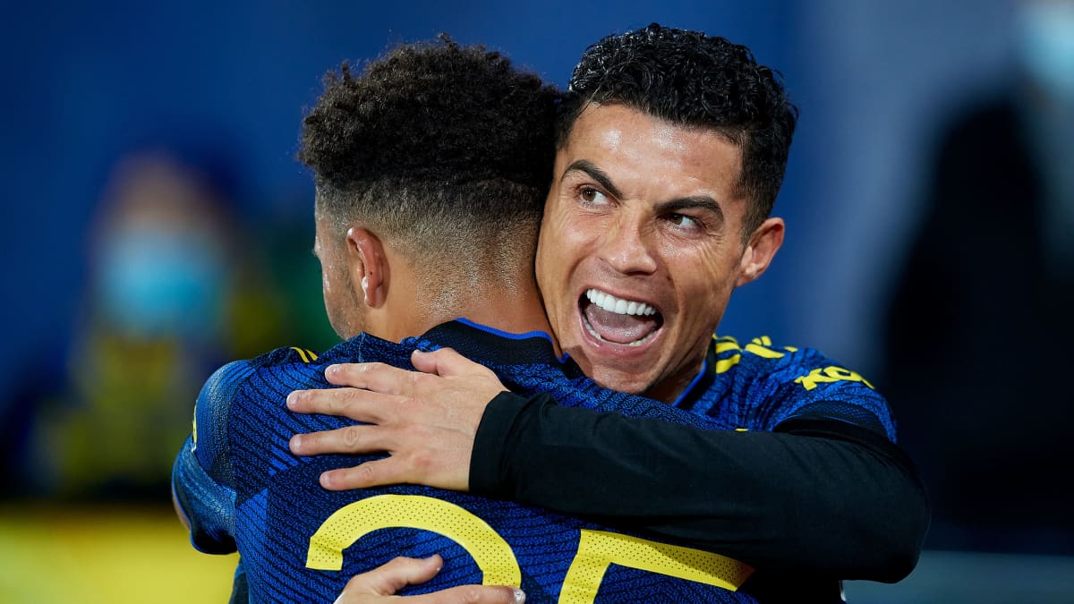 Cristiano Ronaldo halaa joukkuekaveriaan ja virnistää. 