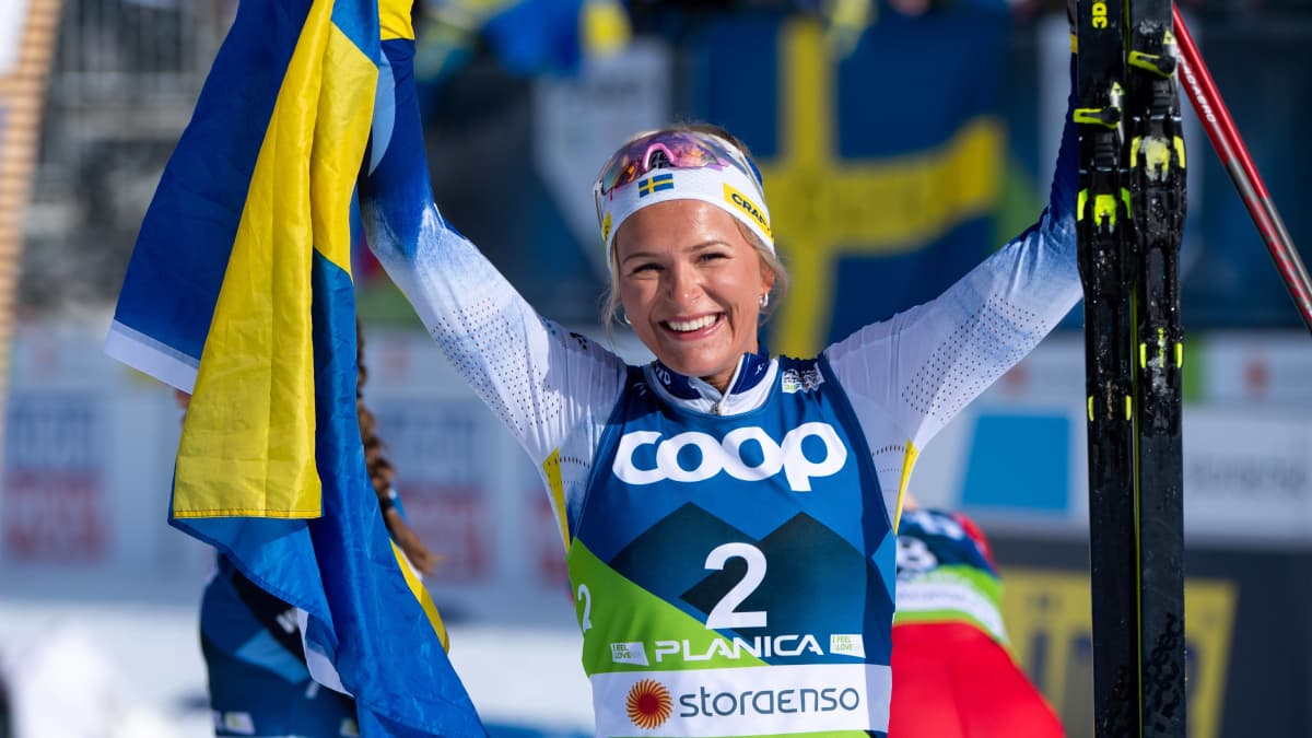 Frida Karlsson juhlii Ruotsin lipun kanssa.