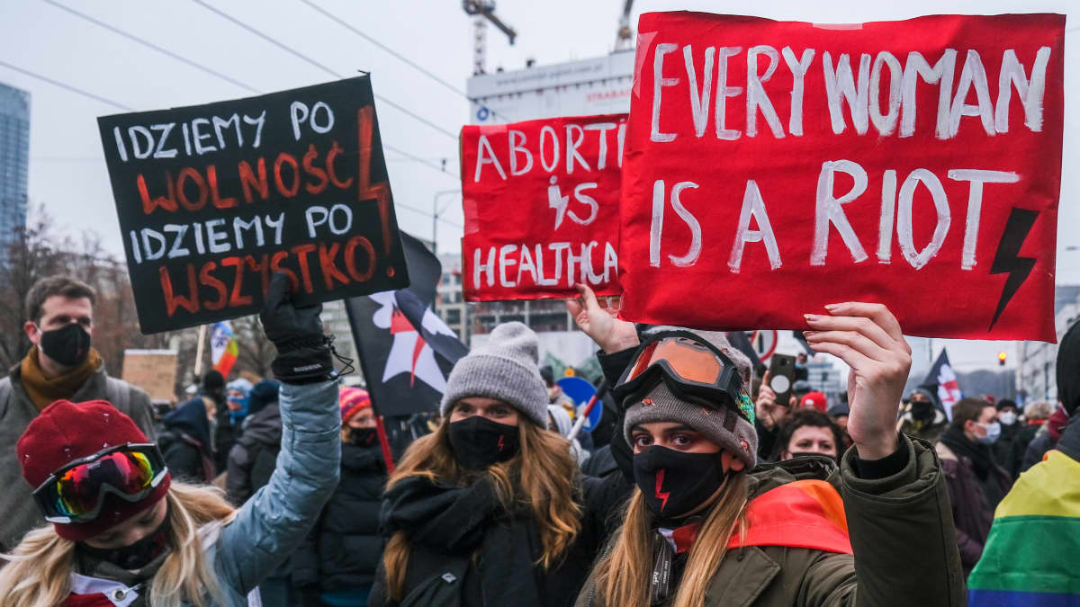 Aborttimielenosoitukseen osallistuvat naiset näyttävät kylttejä.