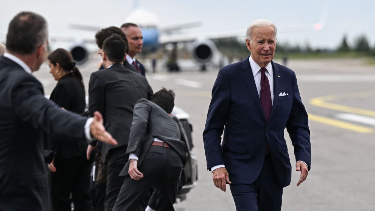 Joe Biden kävelee lentokentällä. Taustalla lentokone.