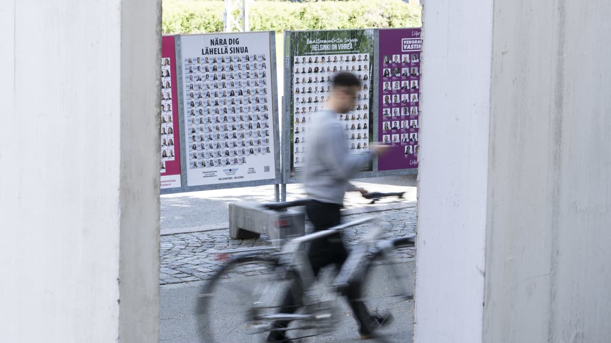 Ihmisiä kävelee kuntavaalimainosten ohi Töölönkadulla Helsingissä.