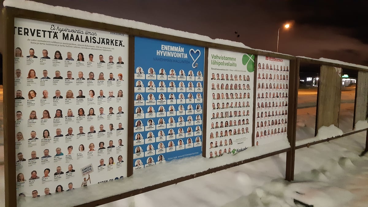 Aluevaalen katumainoksia iltahämärässä talvimaisemassa Seinäjoella.