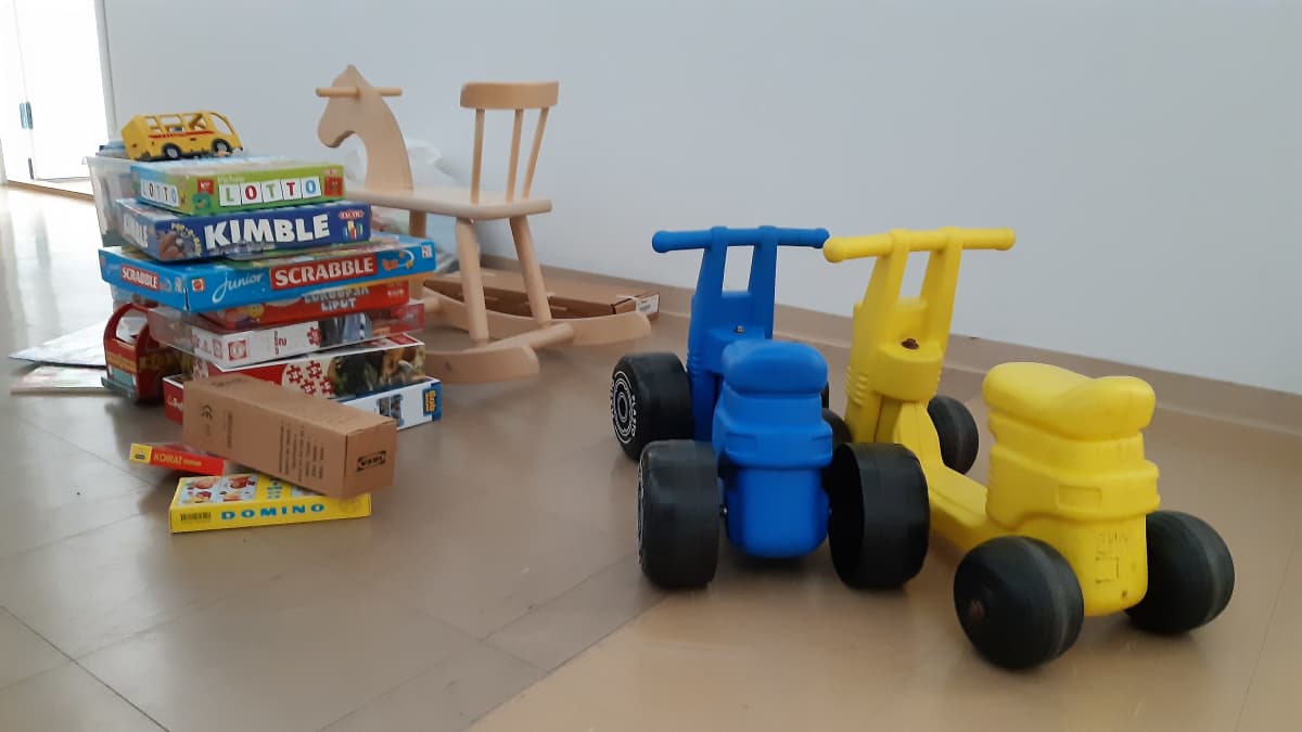Lasten leluja, mopoja ja pelejä SPR.n vastaanottokeskuksen lattialla. 