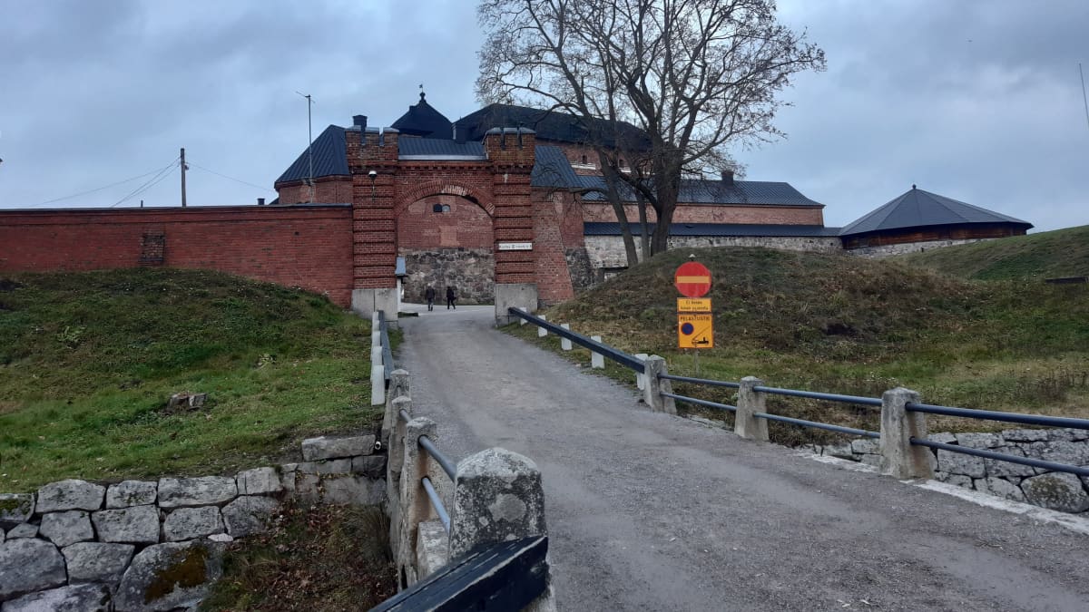 Vanhan sillan päässä näkyy punatiilinen ja mustakattoinen linna.