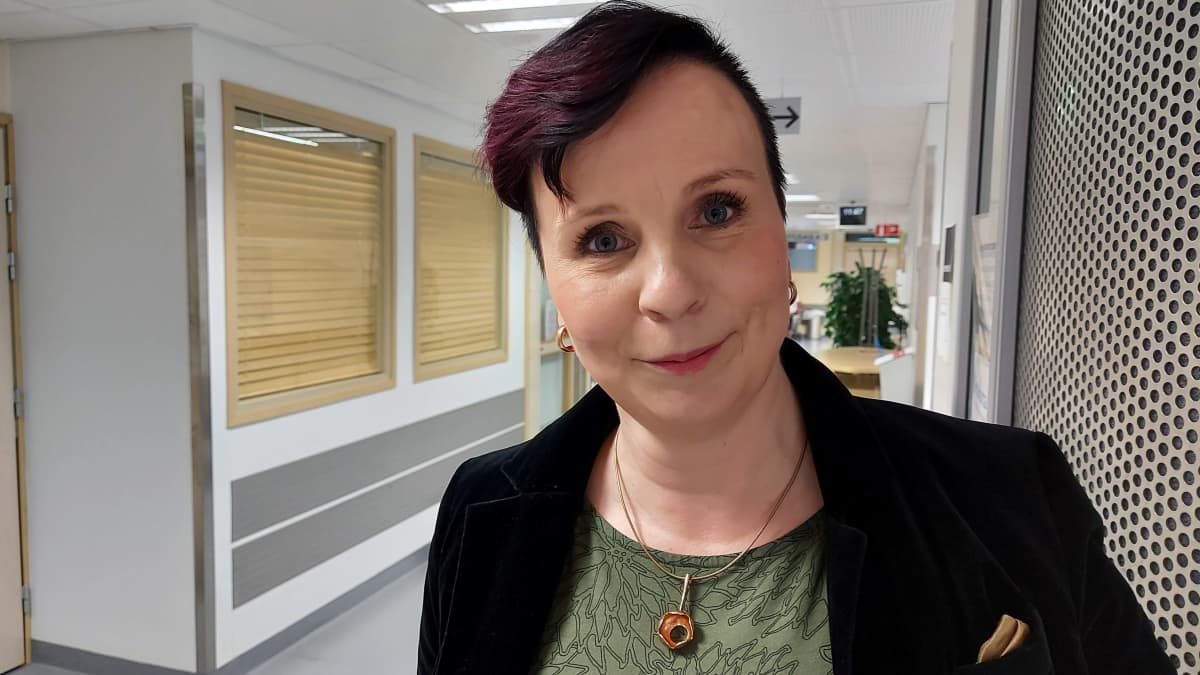 Nainen hymyilee kameralle.