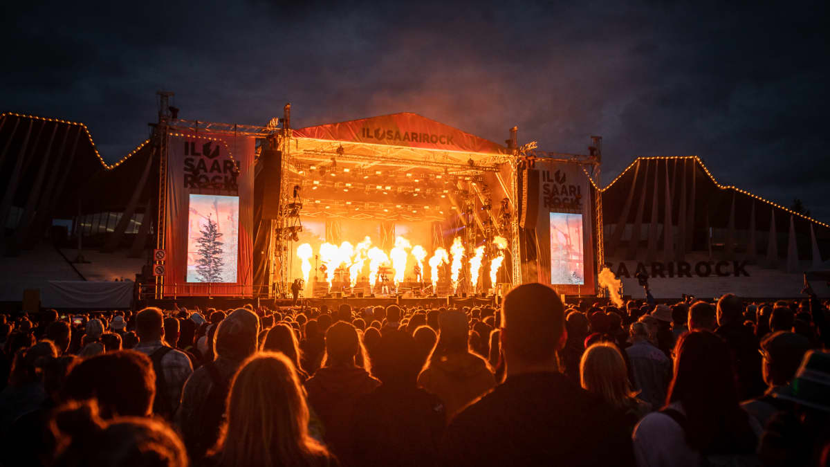 People watching a stage ablaze with pyrotechnic flames at the IlosaariRock festival in 2022.