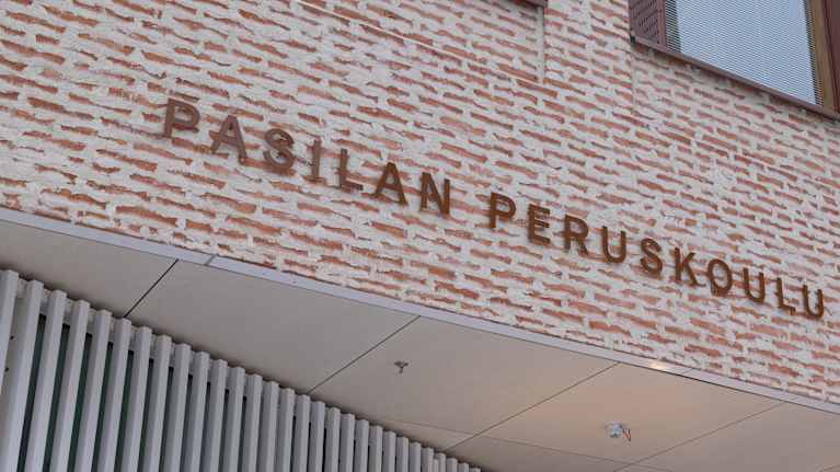 Pasilan peruskoulu teksti koulurakennuksen seinässä. 