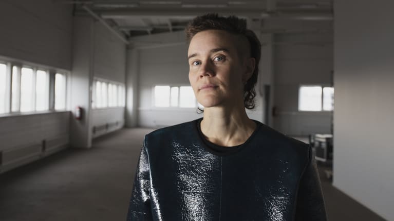 Emilia Kokko tyhjässä entisessä autojenmyyntihallissa ennen ensi-iltaa.